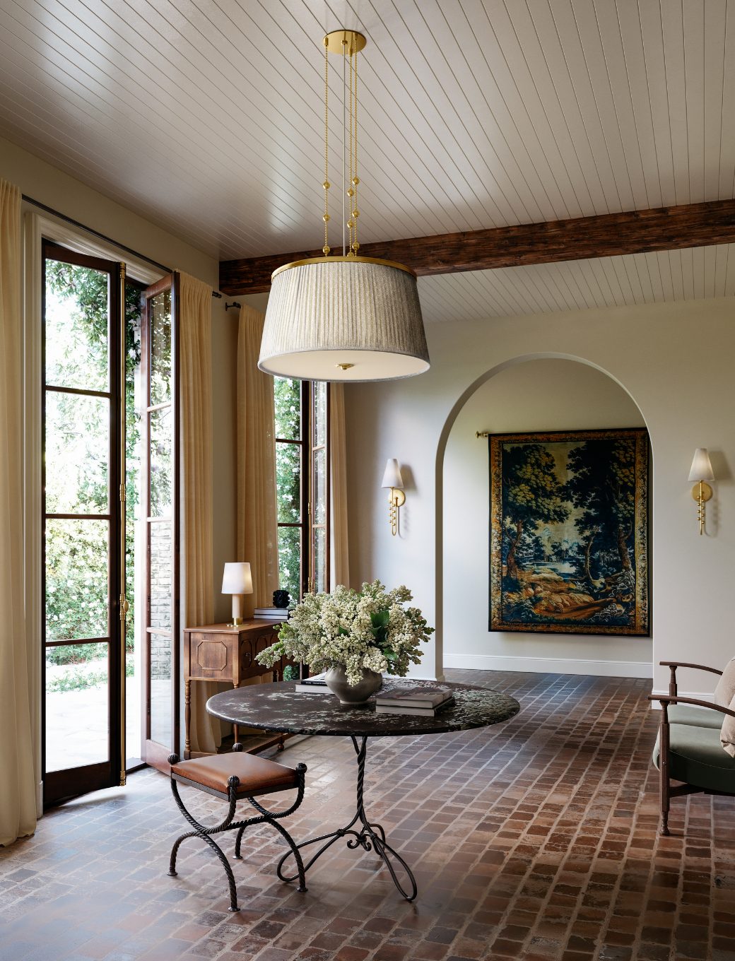 Pleated pendant and matching sconces in a sunlit entry