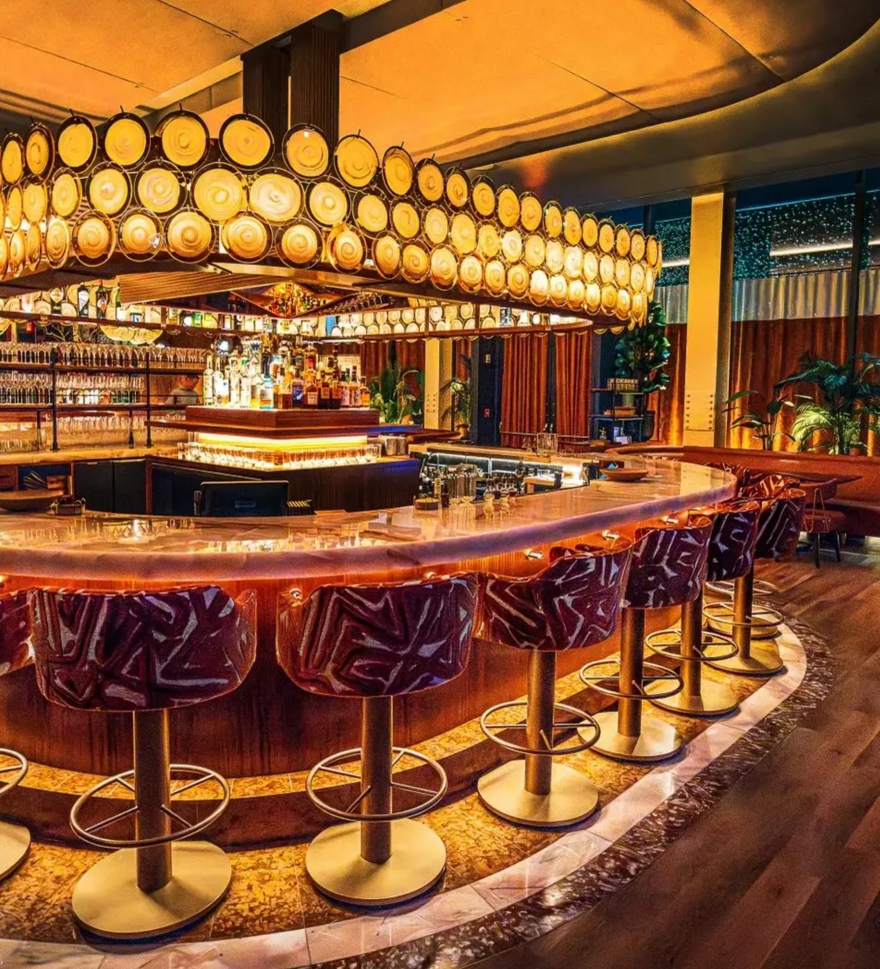 Hospitality bar with custom seating and a warm circular chandelier